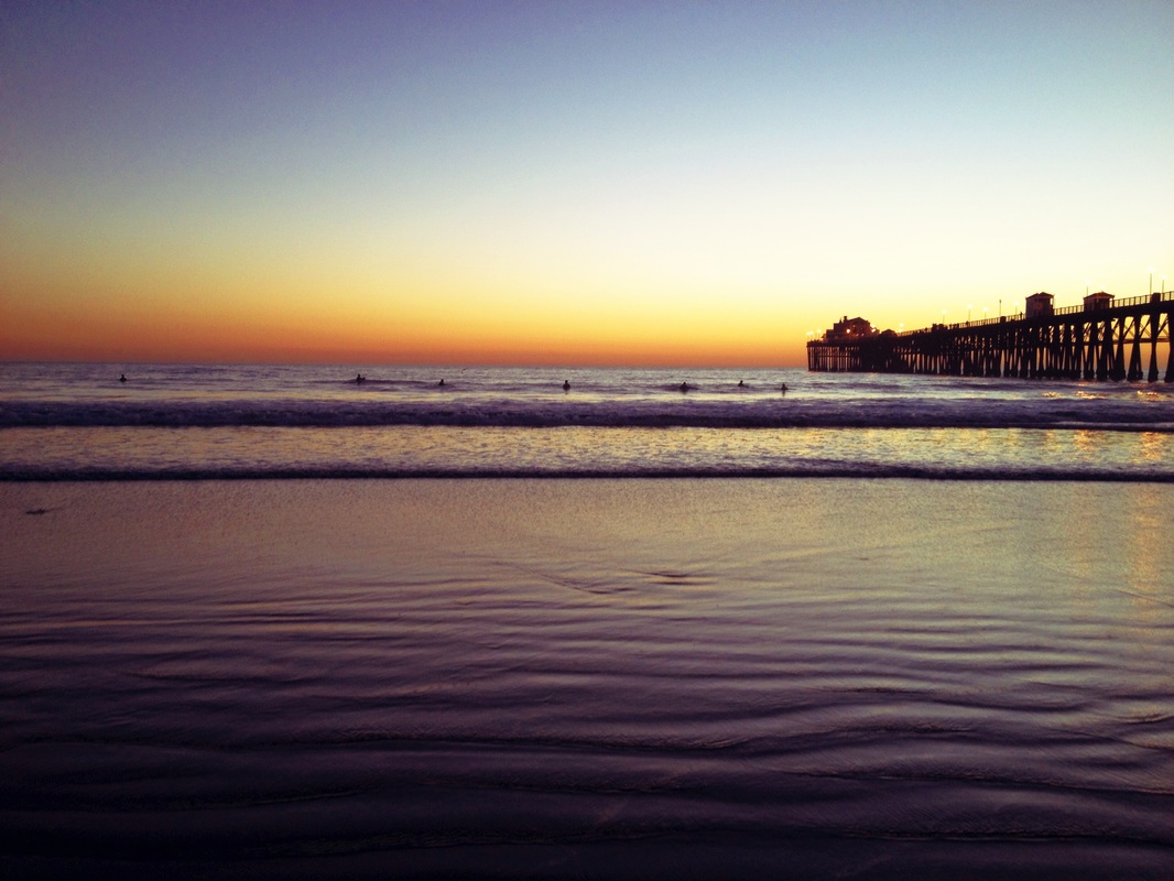 Oceanside beach at Sunset in California. Look at the little surfers!